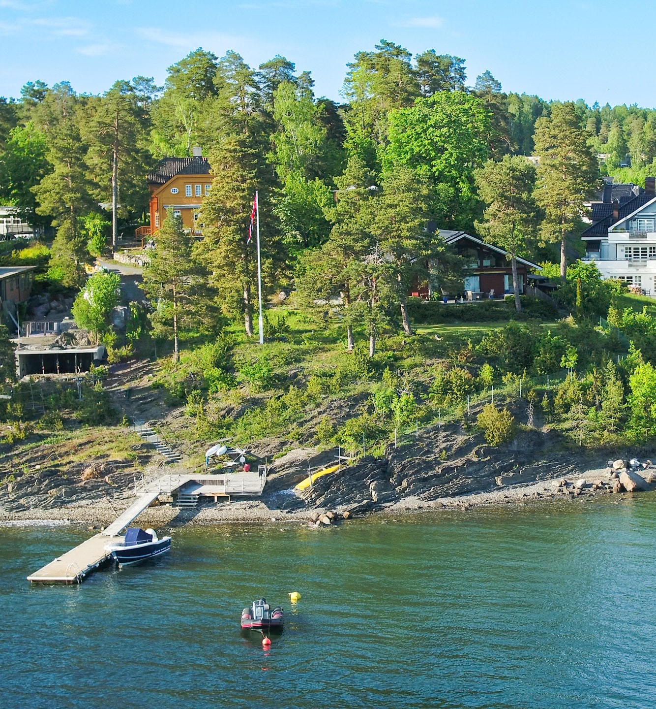 Felles strandparsell med brygge og batfeste som deles mellom 93A,B og C. Fortøyningsbøyen i bukten tilhører 93C Galleribilde