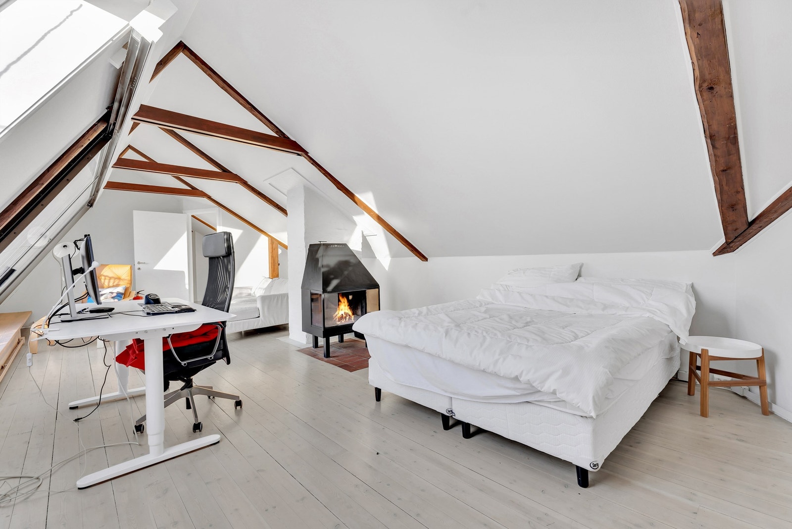 Loftstue med peisovn og utgang til balkong. Galleribilde