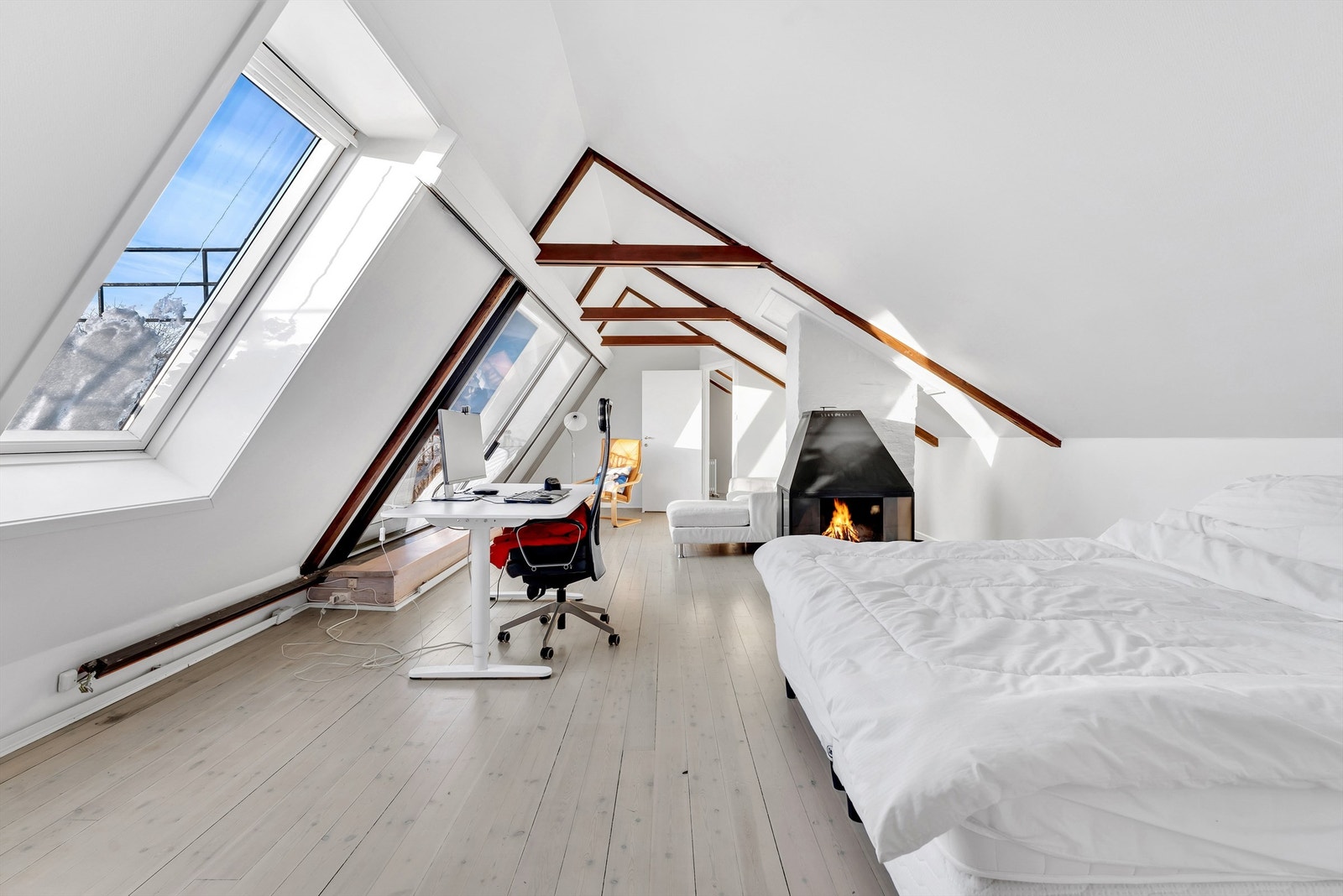 Loftstue med peisovn og utgang til balkong. Galleribilde