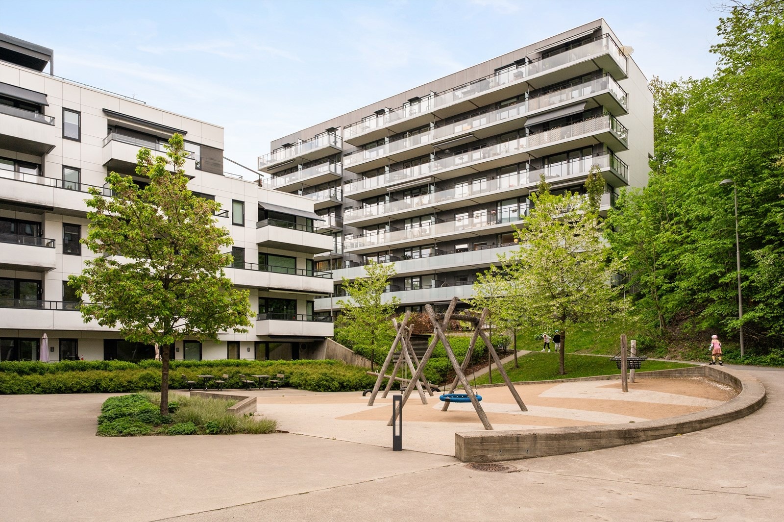 Fellesområdene er pent opparbeidet med gangstier, sittegrupper, lekeområde og koselig beplantning. Galleribilde