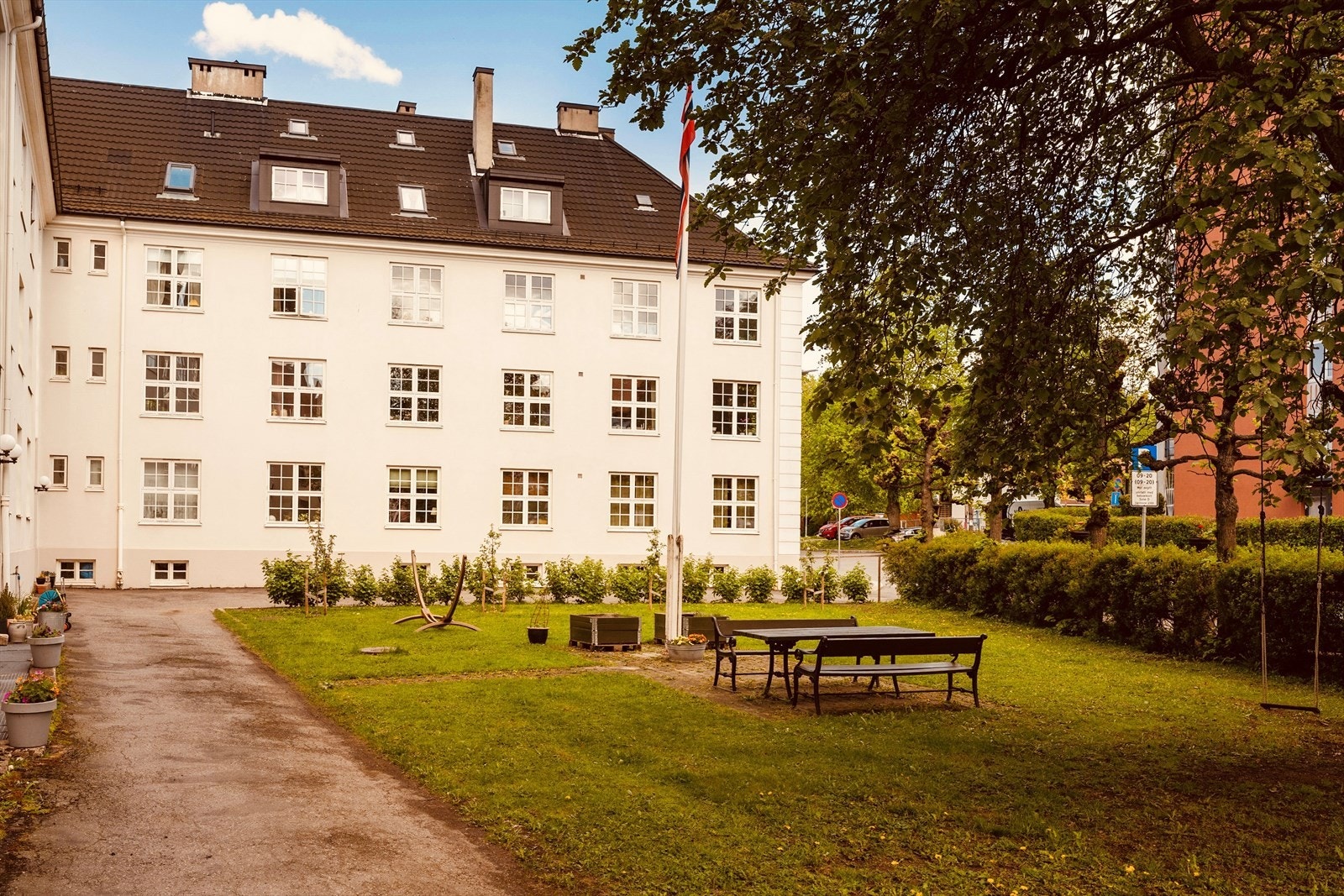 Få trapper ned til den nydelige bakgården som kan benyttes av beboerne. Galleribilde