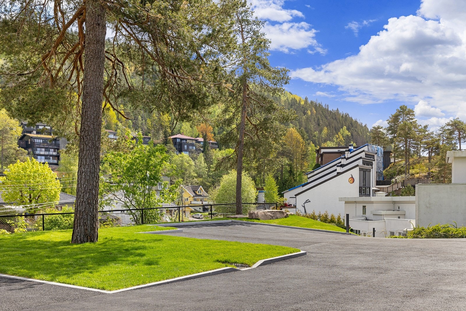 Godt med parkeringsplasser til hver enhet! Gressplenen rundt treet til venstre samt 2 av parkeringsplassene ute på gårdsplassen er tilseksjonert enheten 18 B Galleribilde