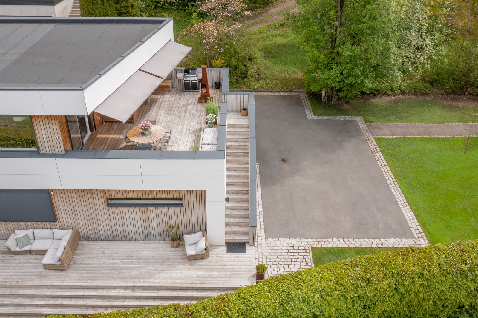 Terrassen har trappeadkomst videre ned til ytterligere terrasse, hageområde og parkeringsplass. Galleribilde