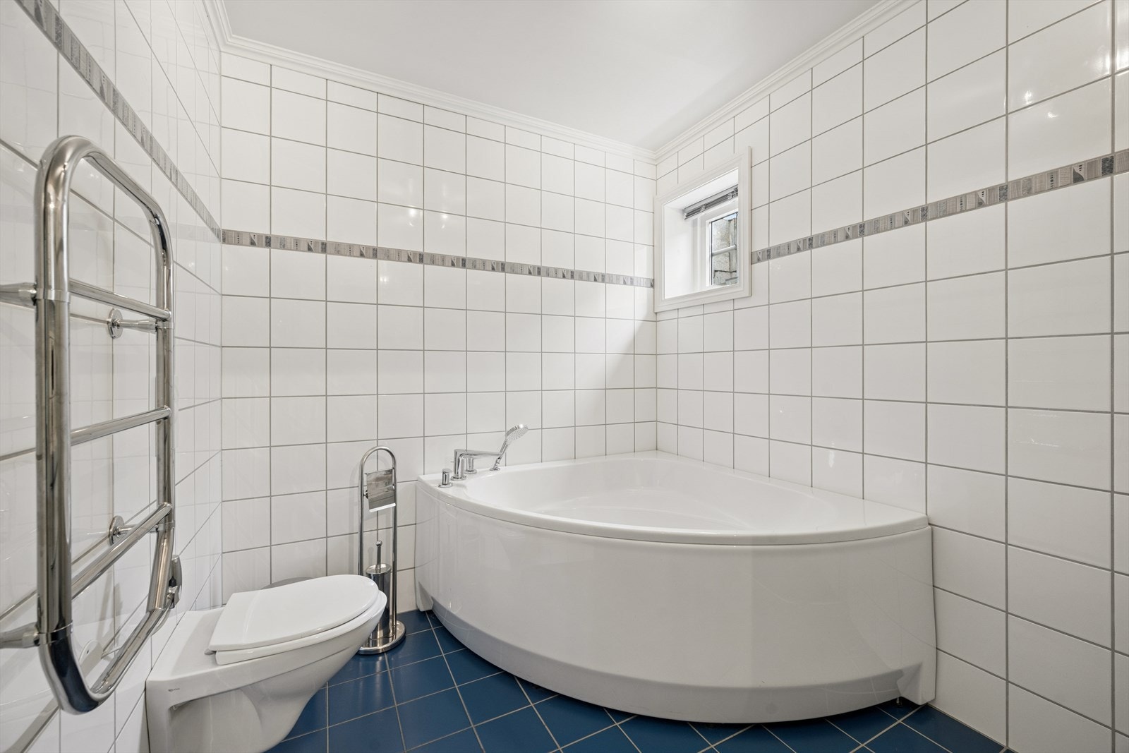 Rommet har flislagte overflater, veggmontert toalett og balansert ventilasjon. Galleribilde