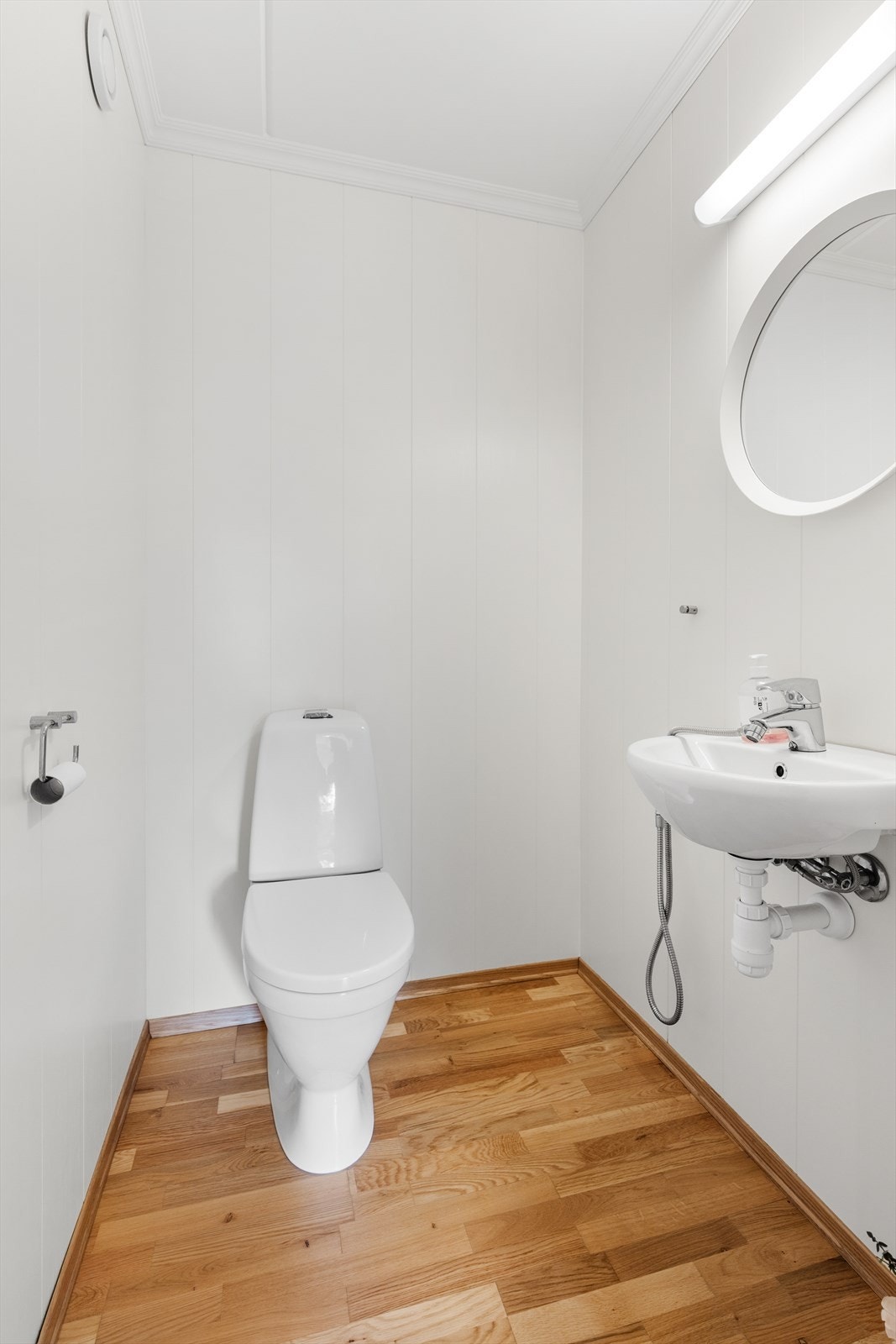 Praktisk toalettrom i tilknytning til entréen, utstyrt med servant og klosett. Galleribilde