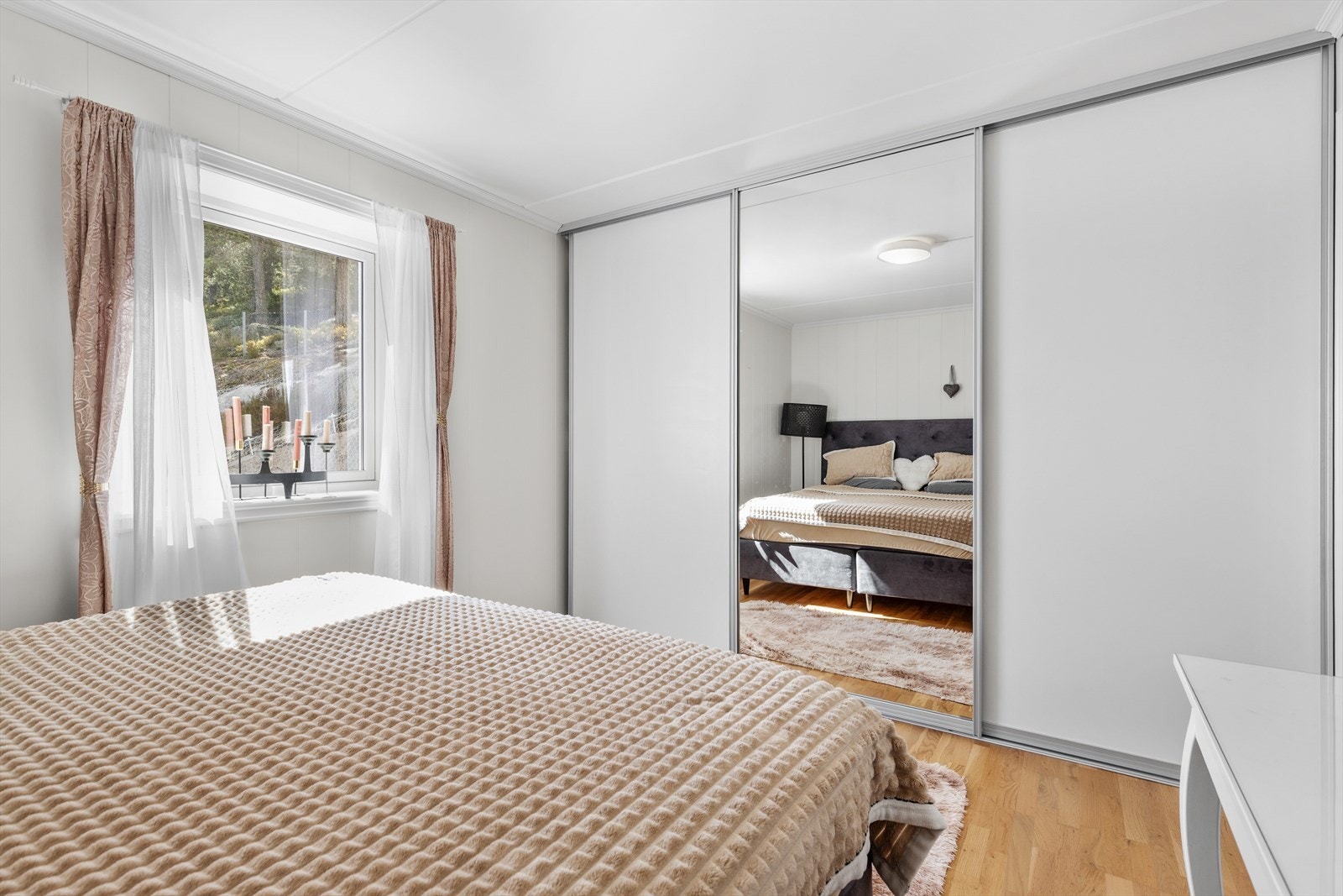 Skyvedørsgarderobe med speilfronter gir effektiv oppbevaring på hovedsoverommet. Galleribilde