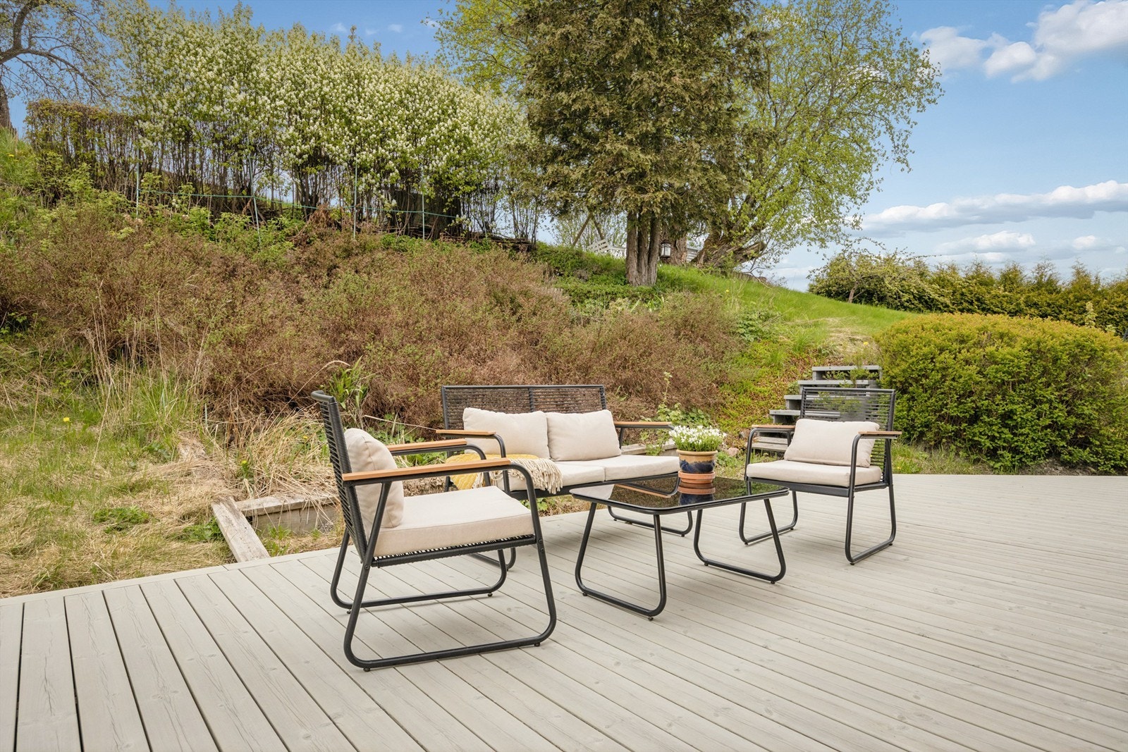 Fin uteplass på terrasseplatting med plass til flere sitteområder Galleribilde