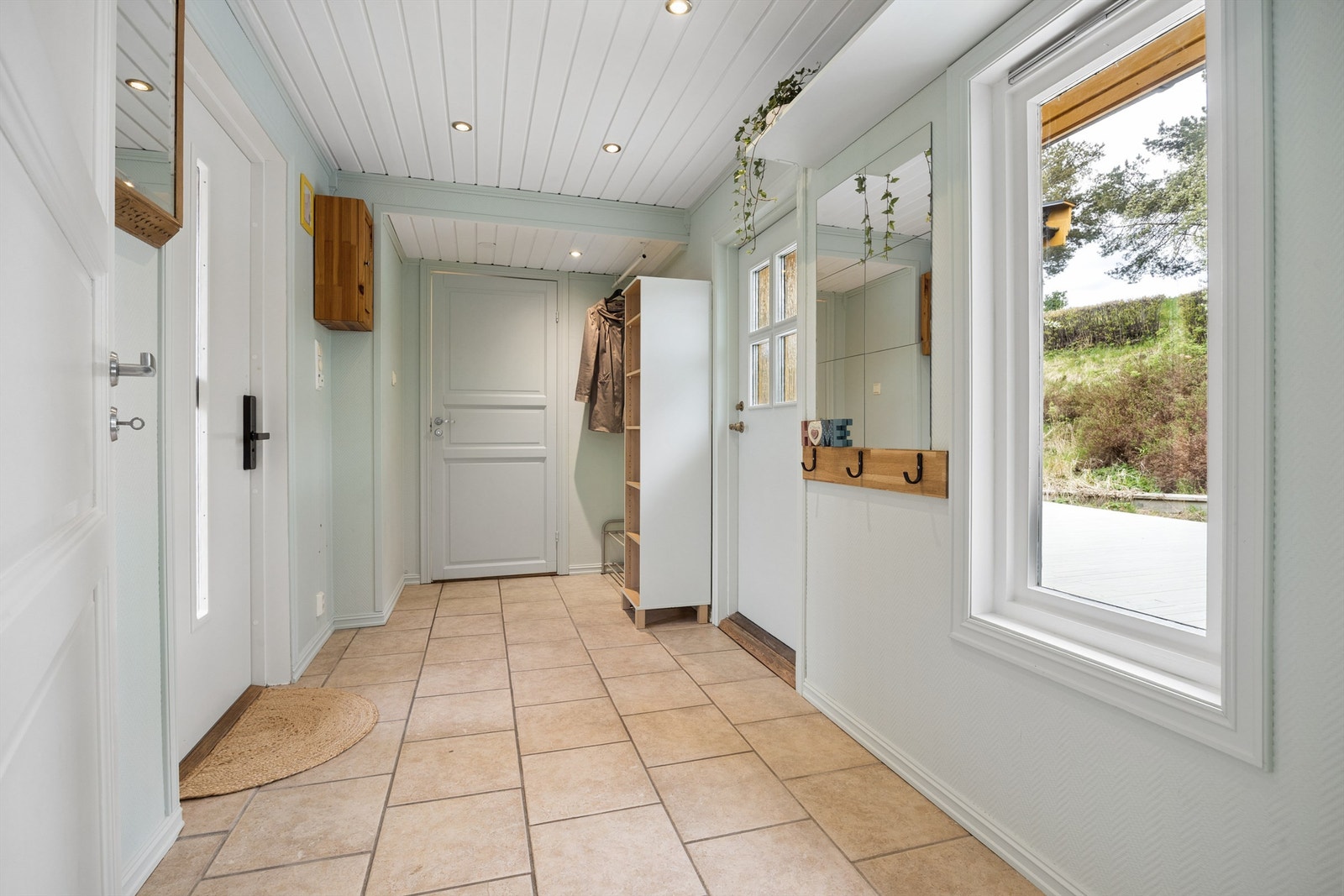 Entré med adkomst til gårdsplassen og til terrasseplatting på baksiden av boligen Galleribilde