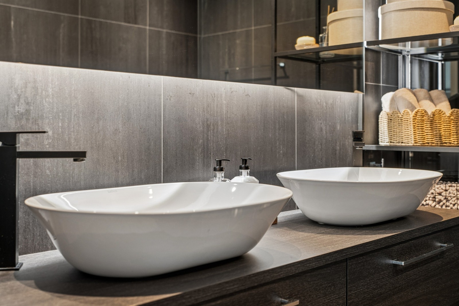 Badet har innredning med to servanter, veggmontert toalett og dusjhjørne. Galleribilde