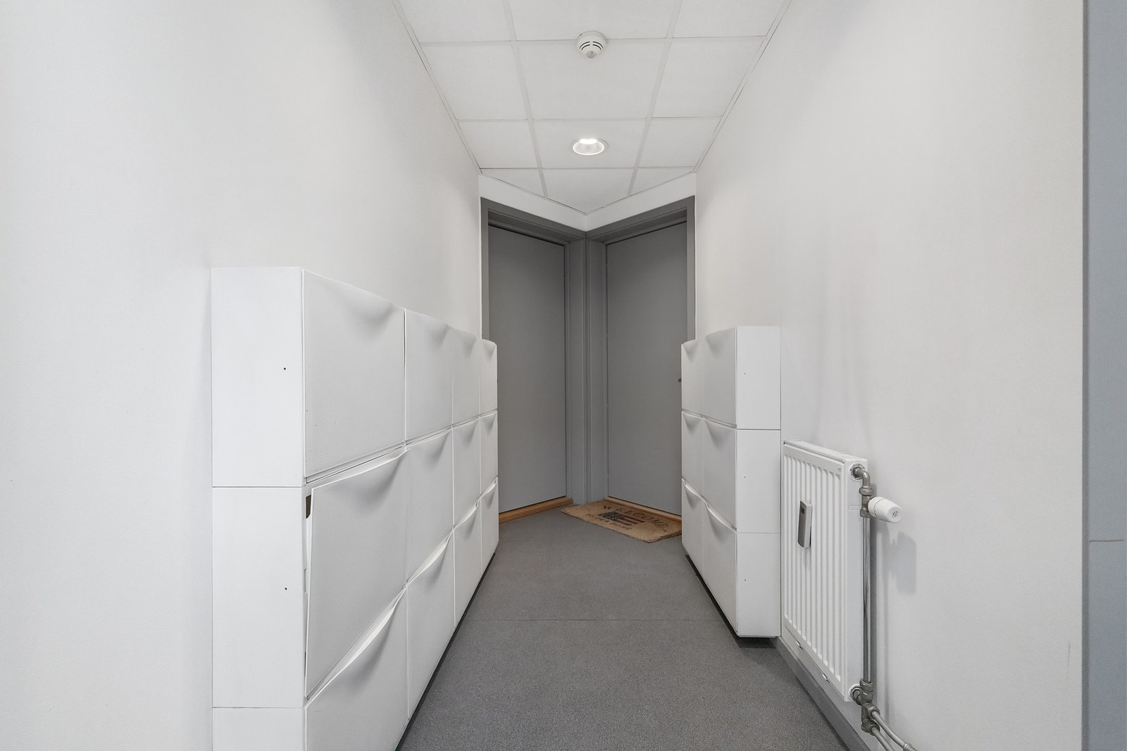 Felles inngang med naboleiligheten med plass til å sette fra seg sko. Galleribilde