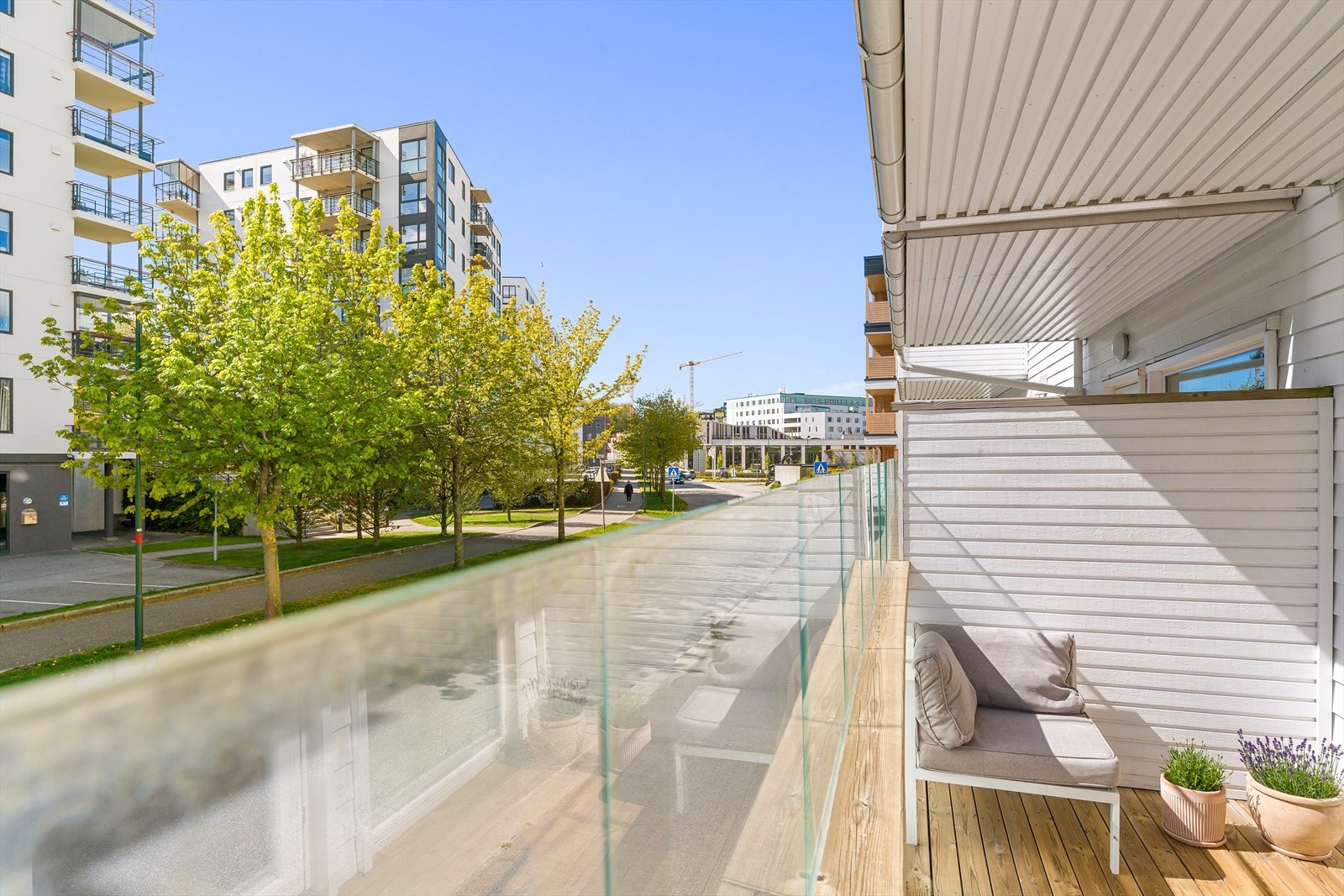 Balkongen er belagt med terrassebord og har rekkverk i tre og glass. Galleribilde