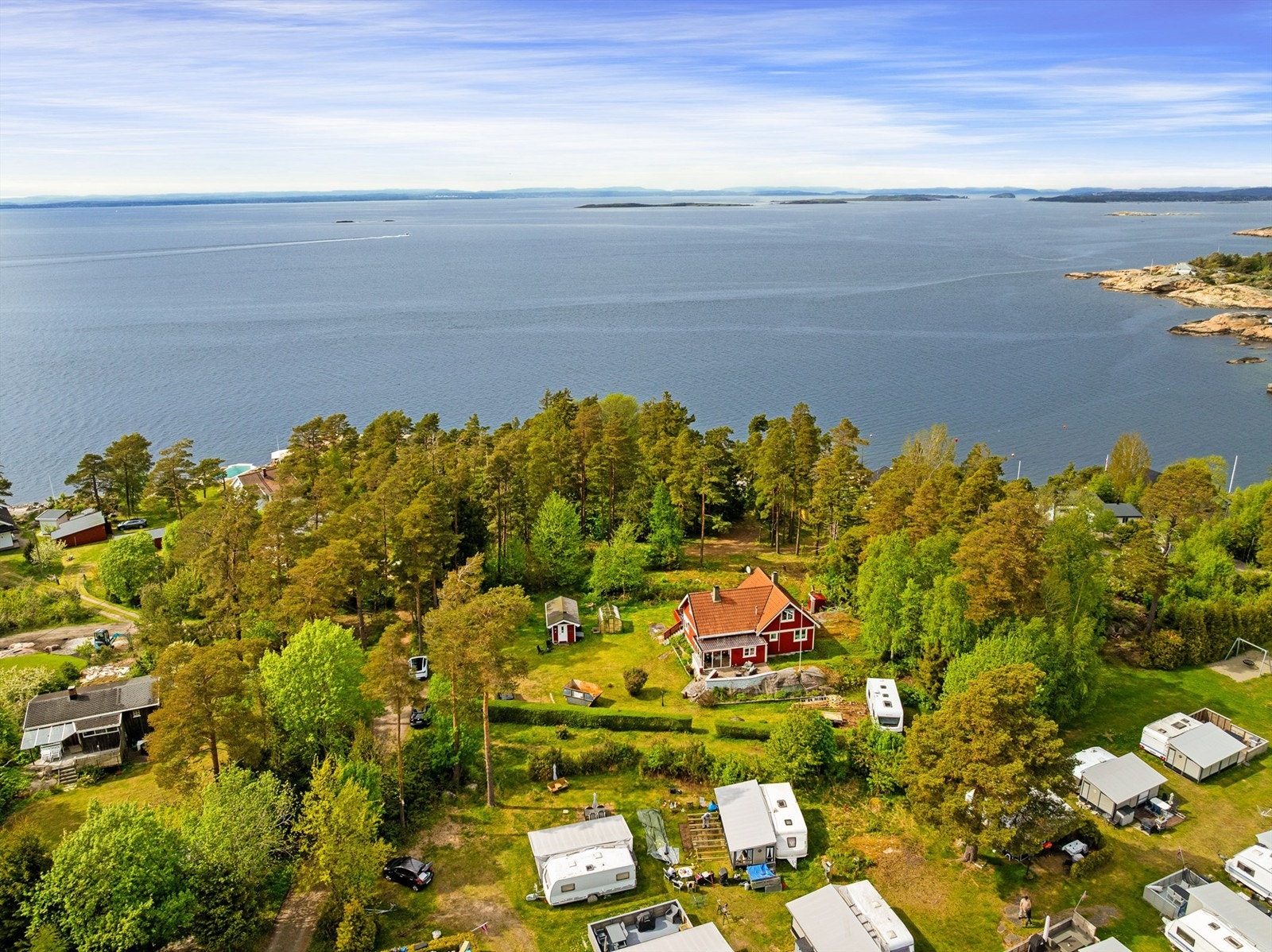 Eiendommen ligger som en stor lysning i skogen, godt avskjermet fra både campingområdet ovenfor og øvrige fritidsboliger omkring. Galleribilde
