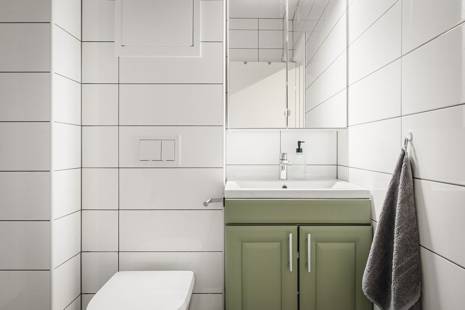Badet er innredet med vegghengt toalett, vask m/skapplass under, skap med speil og dusjhjørne Galleribilde
