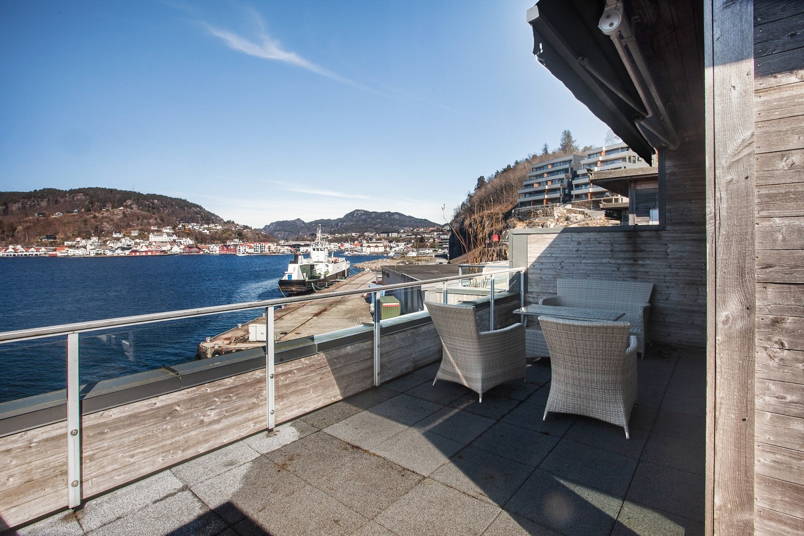 Terrassen i 2. etasje er leilighetens virkelige høydepunkt! Her kan du nyte flott utsikt over fjorden og mot Flekkefjord sentrum i rolige og maritime omgivelser. Galleribilde