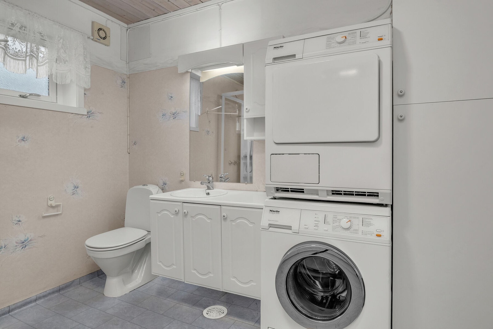 Rommet er utstyrt med elektrisk gulvvarme, servant på innredning, wc, dusjkabinett og opplegg for vaskemaskin. Galleribilde