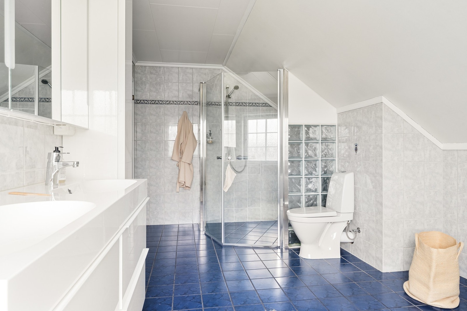 Badet er innredet med toalett, baderomsinnredning med servant, dusjhjørne og badekar. Galleribilde
