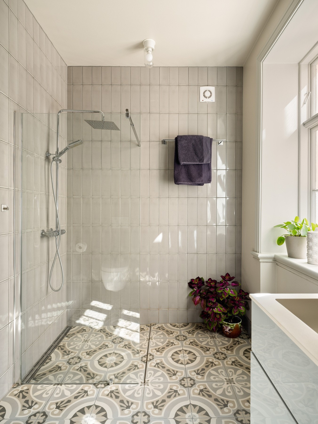 Badet er utstyrt med vegghengt toalett, servant med stilrent servantskap og dusjnisje. Galleribilde