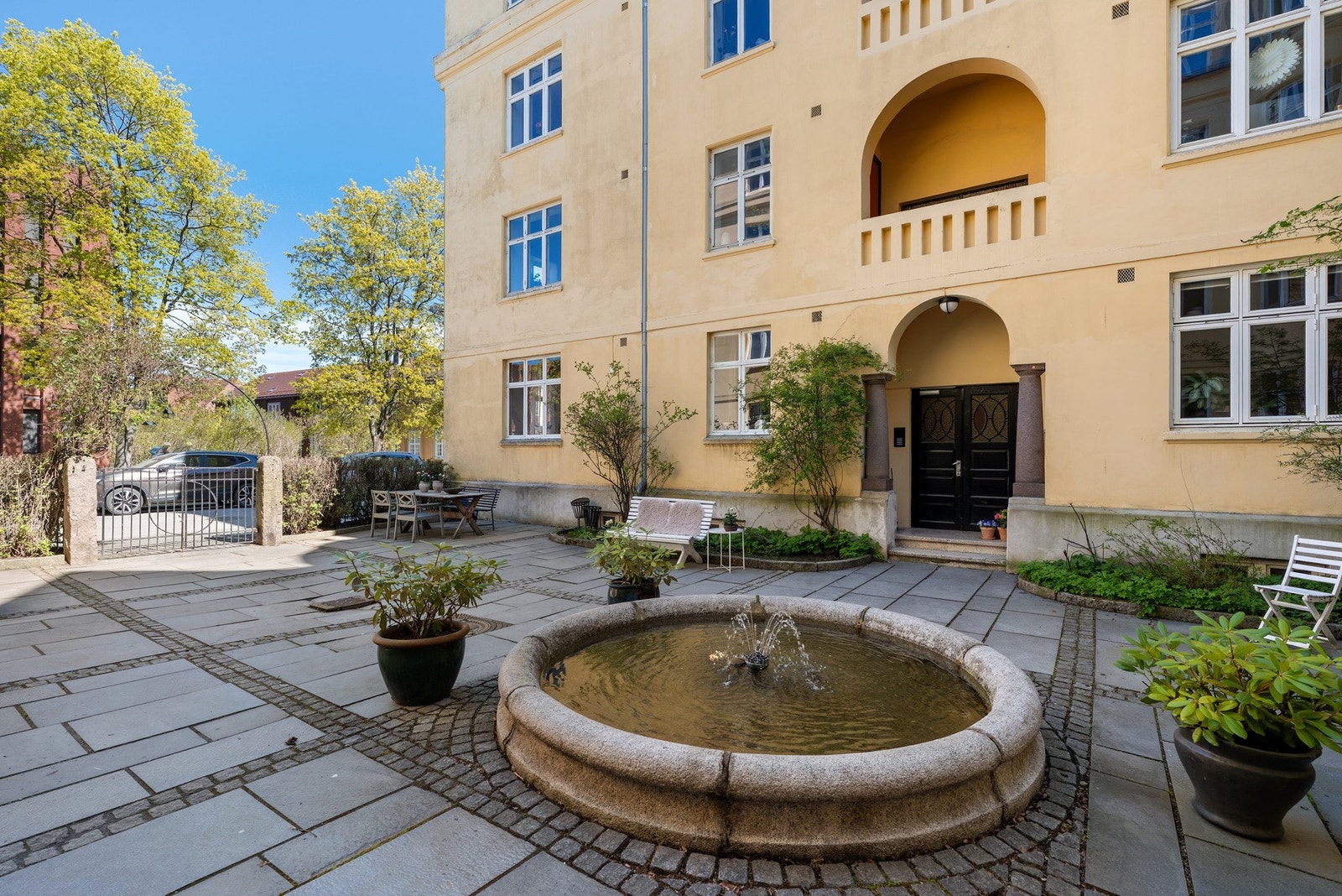 En koselig skjermet felles bakgård i sameiet med en nydelig fontene. Galleribilde