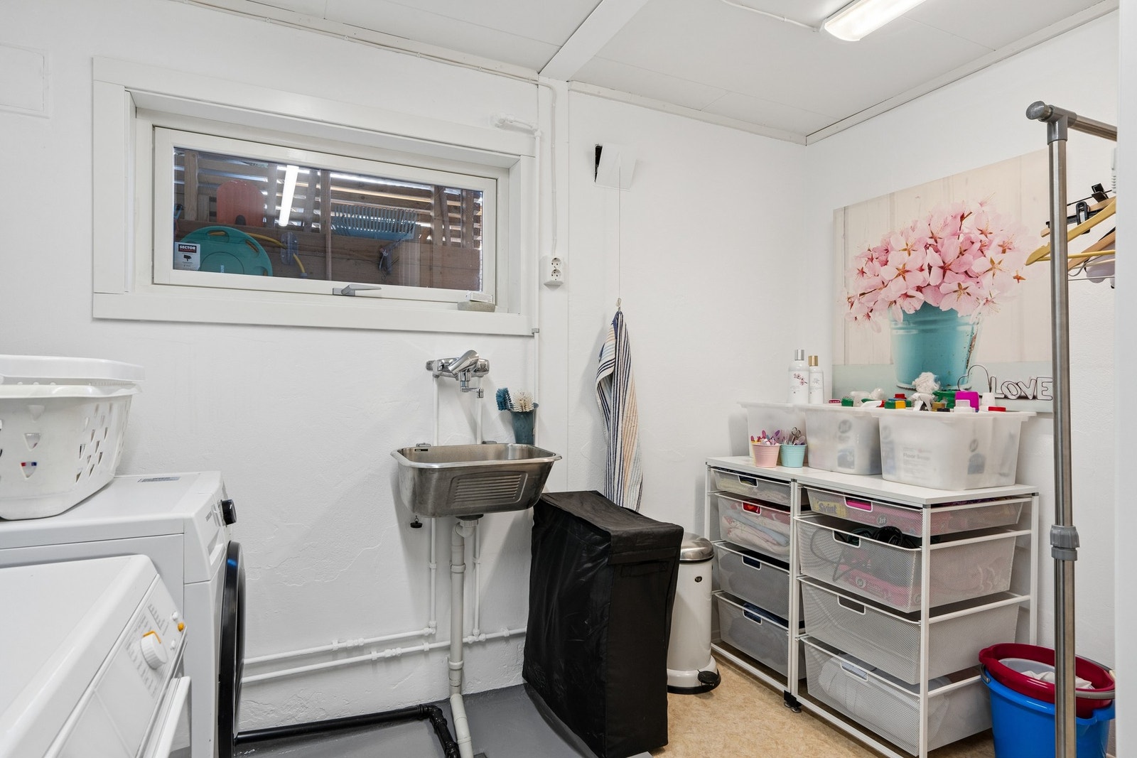 Praktisk og romslig vaskerom i underetasjen, med utslagsvask og opplegg for vaskemaskin. Galleribilde