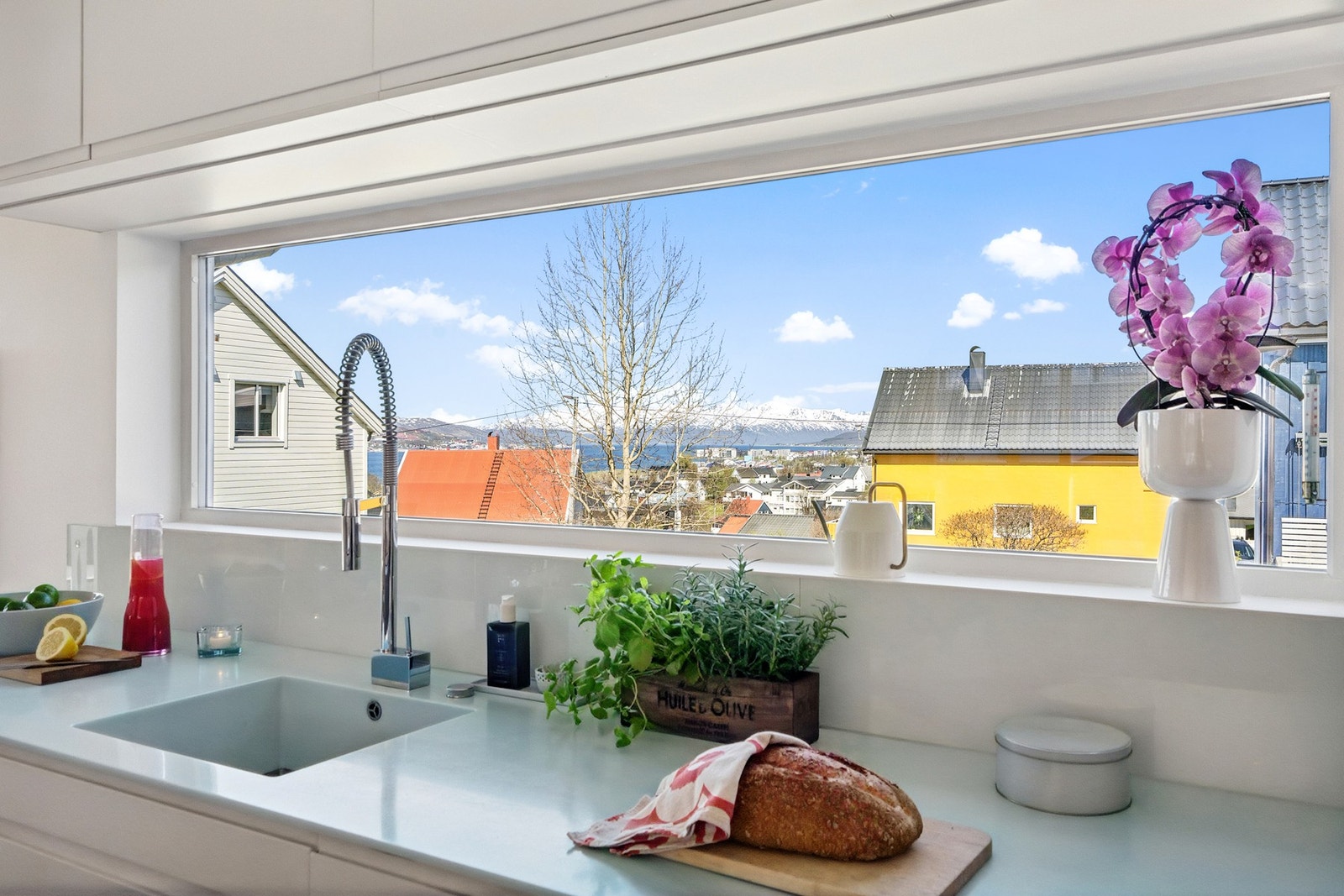 Det lange, horisontale vinduet over kjøkkenbenken, er et sentralt designelement som rammer inn utsikten. Galleribilde