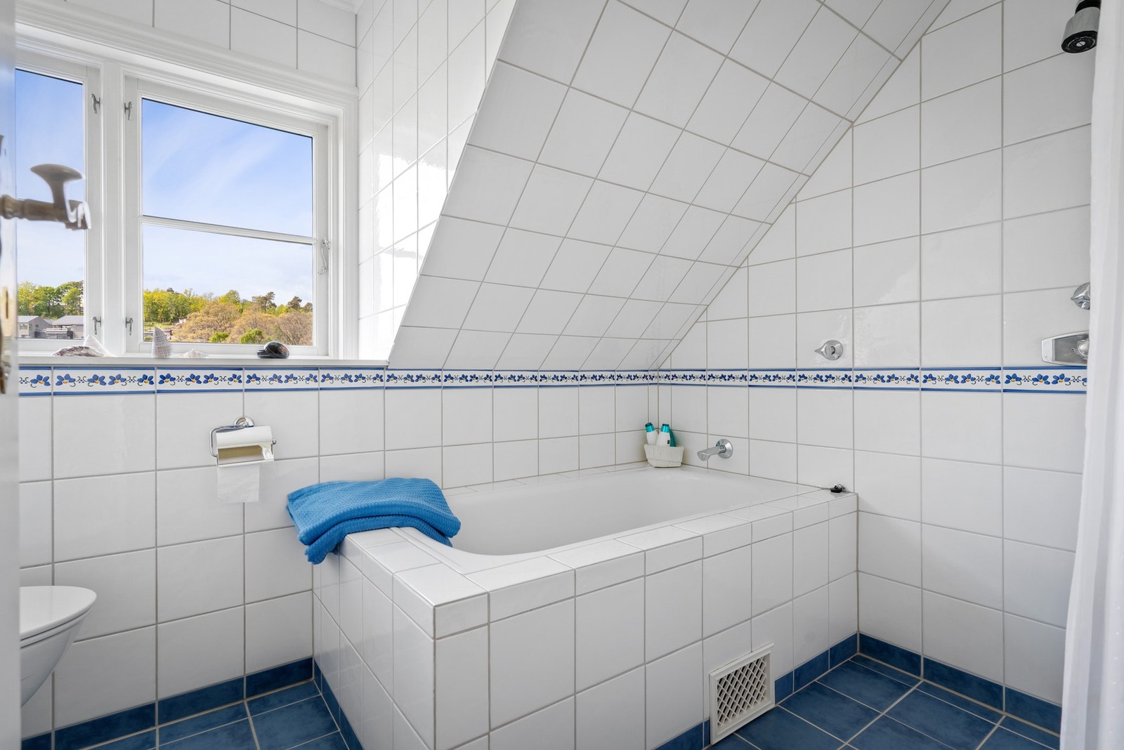 Baderomsinnredning bestående av benkeskap med profilerte fronter. Det er badekar og dusj. Galleribilde