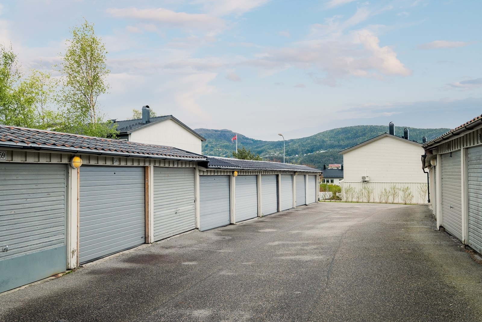 Garasjeplass med elektrisk garasjeport og El-lader følger andel ca. 40m fra inngangsdør. Ellers felles parkeringsplass ca. 30m fra inngangsdør. Galleribilde