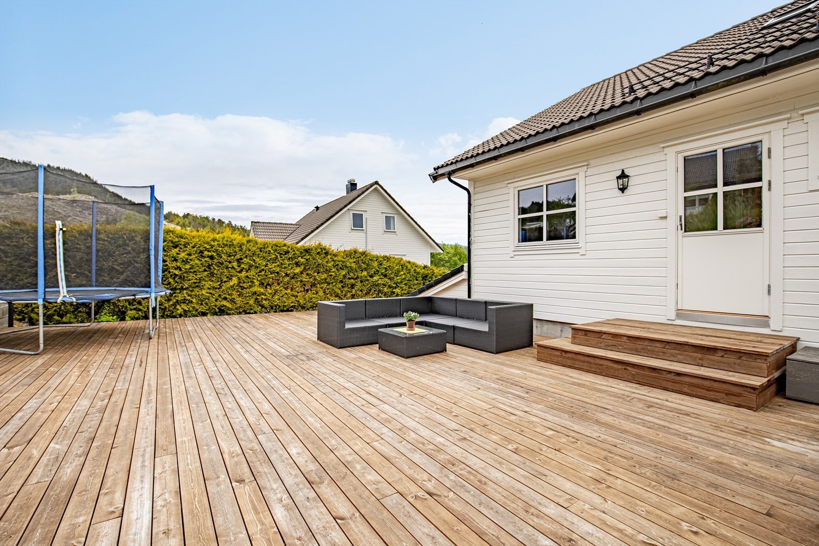 Stor, skjermet terrasse på hele 100 m² med levegg mot nabo ble oppført i 2021/2022 | tilkomst fra gang i hovedetasjen og via utvendig trapp Galleribilde