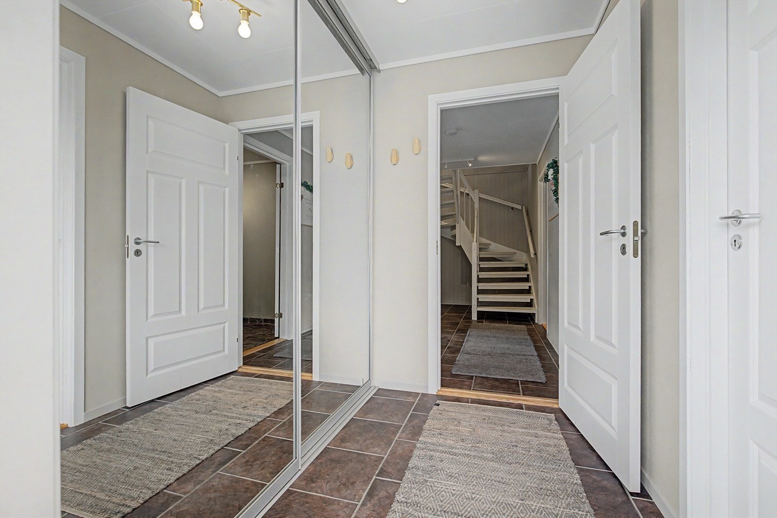Entré mot gang i kjelleretasjen | stor, praktisk skyvedørsgarderobe er montert her Galleribilde