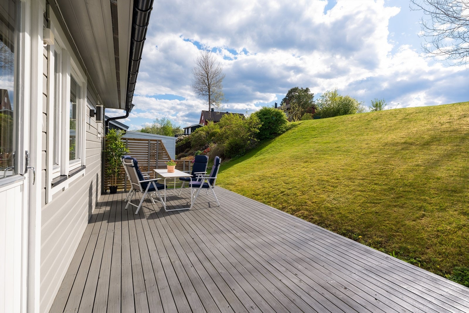 Grønne og frodige omgivelser - På baksiden av huset kan man nyte solen resten av dagen, og på toppen av skråningen kan man etablere en vinterhage om ønskelig. Galleribilde