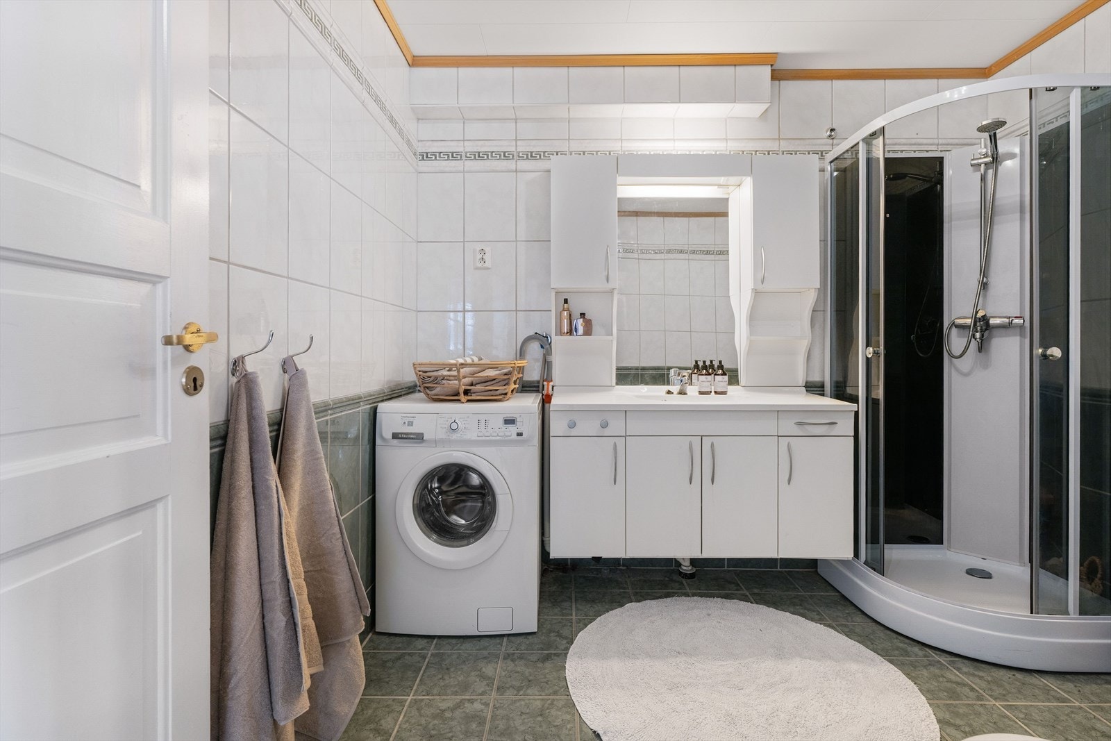 Baderommet er av en god størrelse og måler 7 m². Det flislagte badeværelset er utstyrt med en praktisk og romslig baderomsinnredning med mye oppbevaringsplass, dusjkabinett, toalett og opplegg for vaskemaskin og tørketrommel. Galleribilde