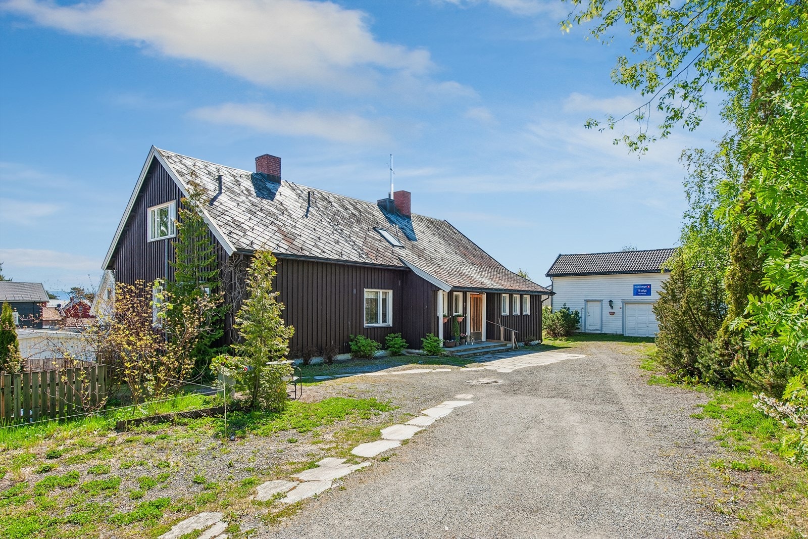Fasade inngangsparti. Stor og romslig gårdsplass samt garasje i stort uthus. Galleribilde