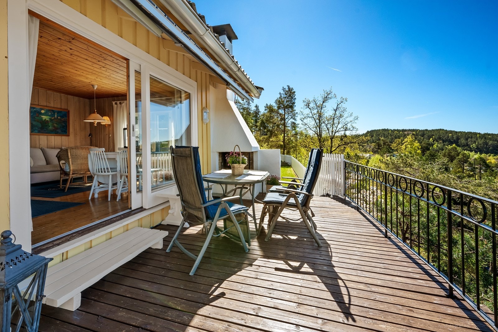 Terrassen har tremmegulv av impregnerte bord og et rekkverk i smijern. Galleribilde