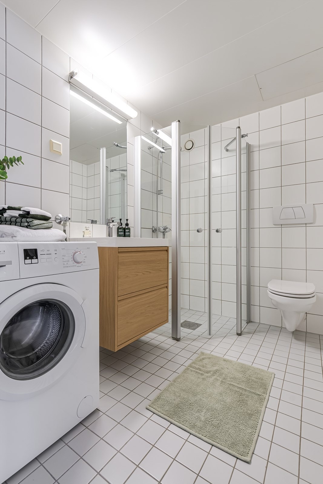 Badet er utført med fliser på vegg og gulv. Badet er et prefabrikert kabinbad med malte stålplater i taket. Badet er fra byggeår. Galleribilde
