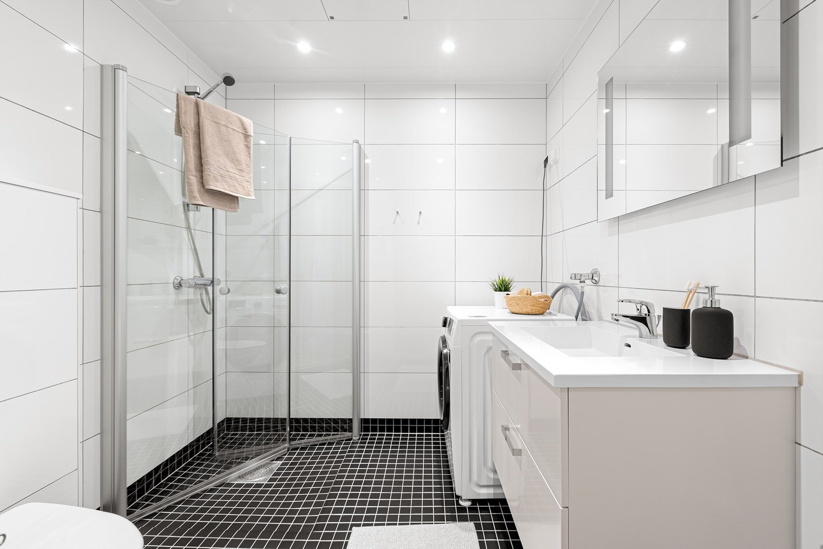 Det 4,5 m² store badet fremstår som innbydende med helflisede overflater, behagelig gulvvarme og downlights i tak. Galleribilde
