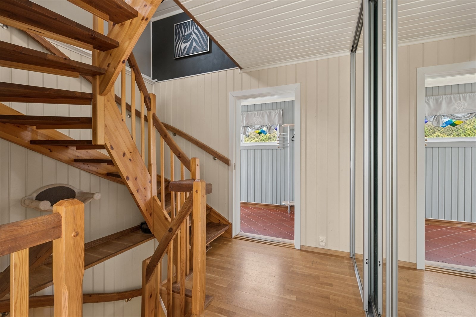 Langs veggen er det skyvedørsgarderobe med speilfront, som gir god oppbevaringsplass rett ved inngangen. Galleribilde