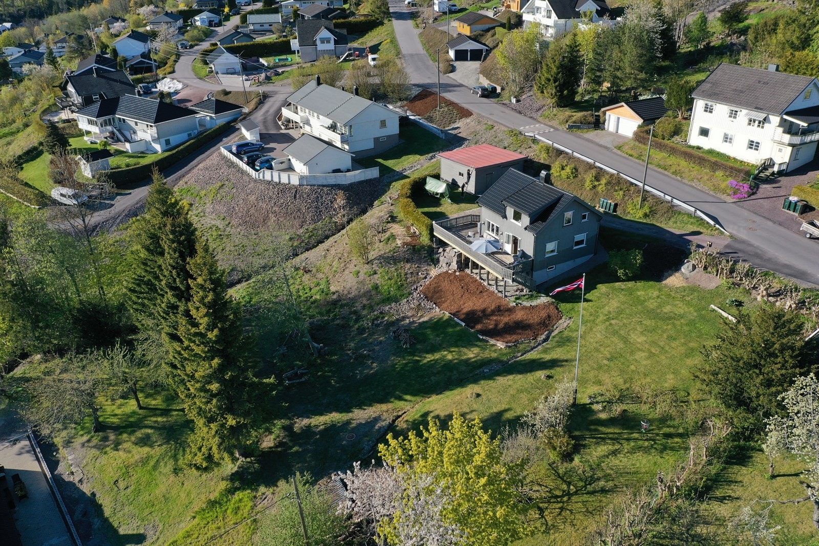 Tomten er stor og skrånende, med et beregnet areal på ca. 1 964,2 kvm. Den er pent opparbeidet med hageområde med plen, steinsatt uteplass og gruset gårdsplass. Galleribilde