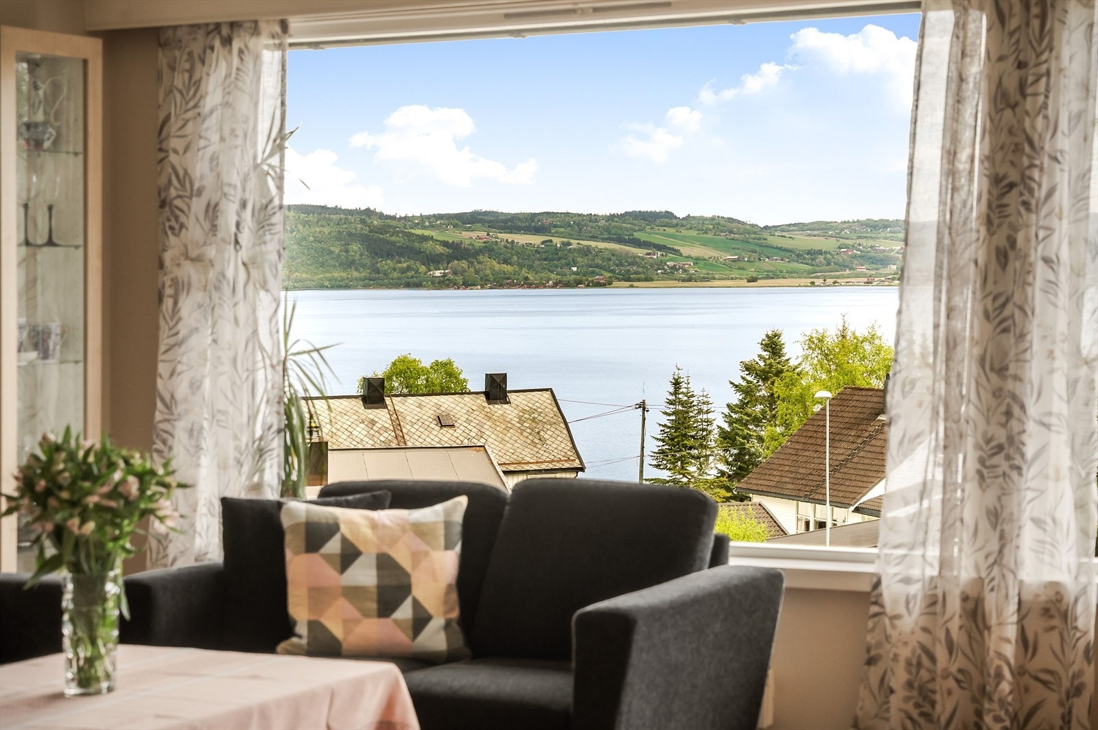 Her blir utsikten en tydelig del av romopplevelsen, og fra sofasonen kan man se utover fjorden og åssidene på andre siden. Galleribilde