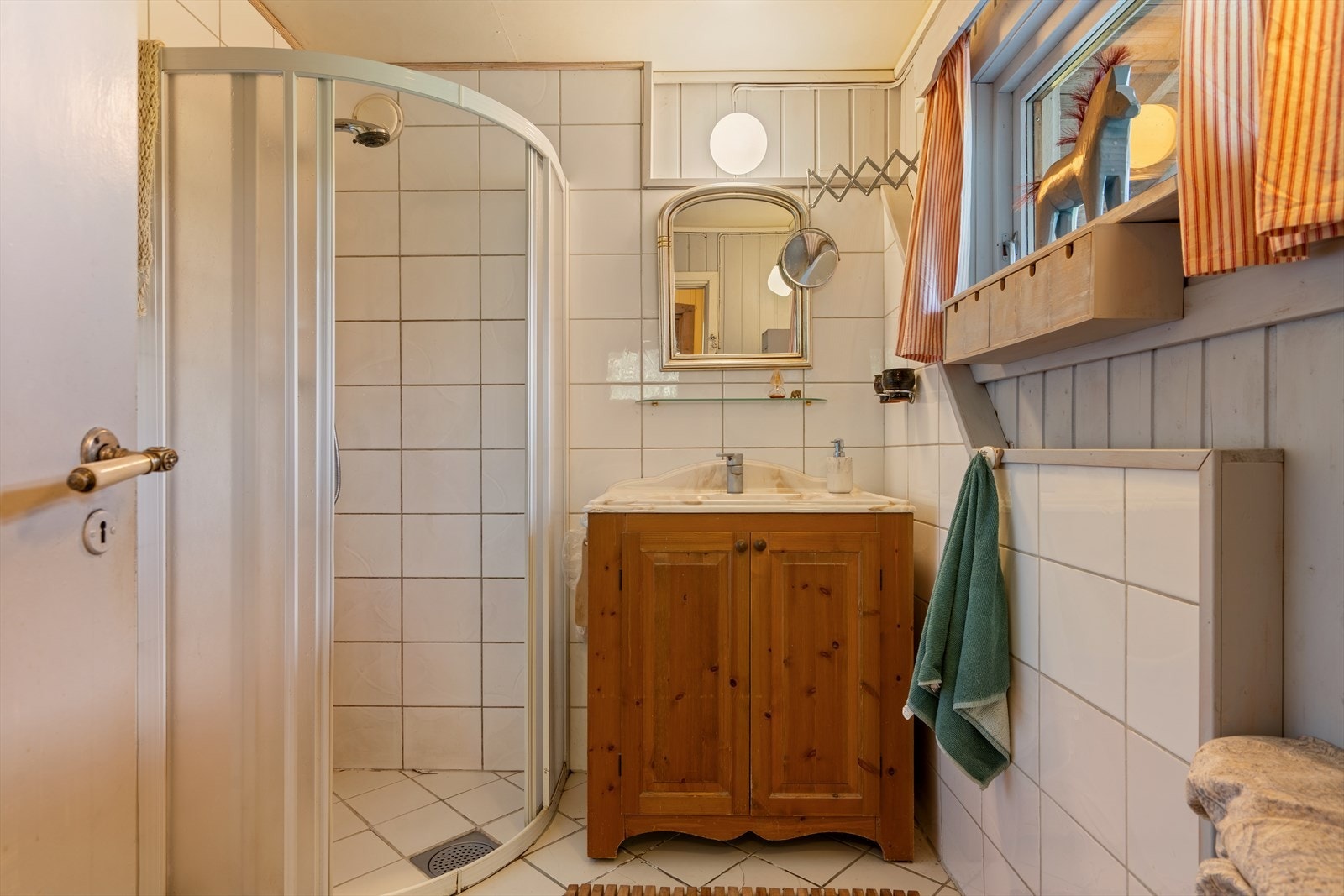 Badet er utstyrt med dusjkabinett, servant i innredning og toalett. Galleribilde