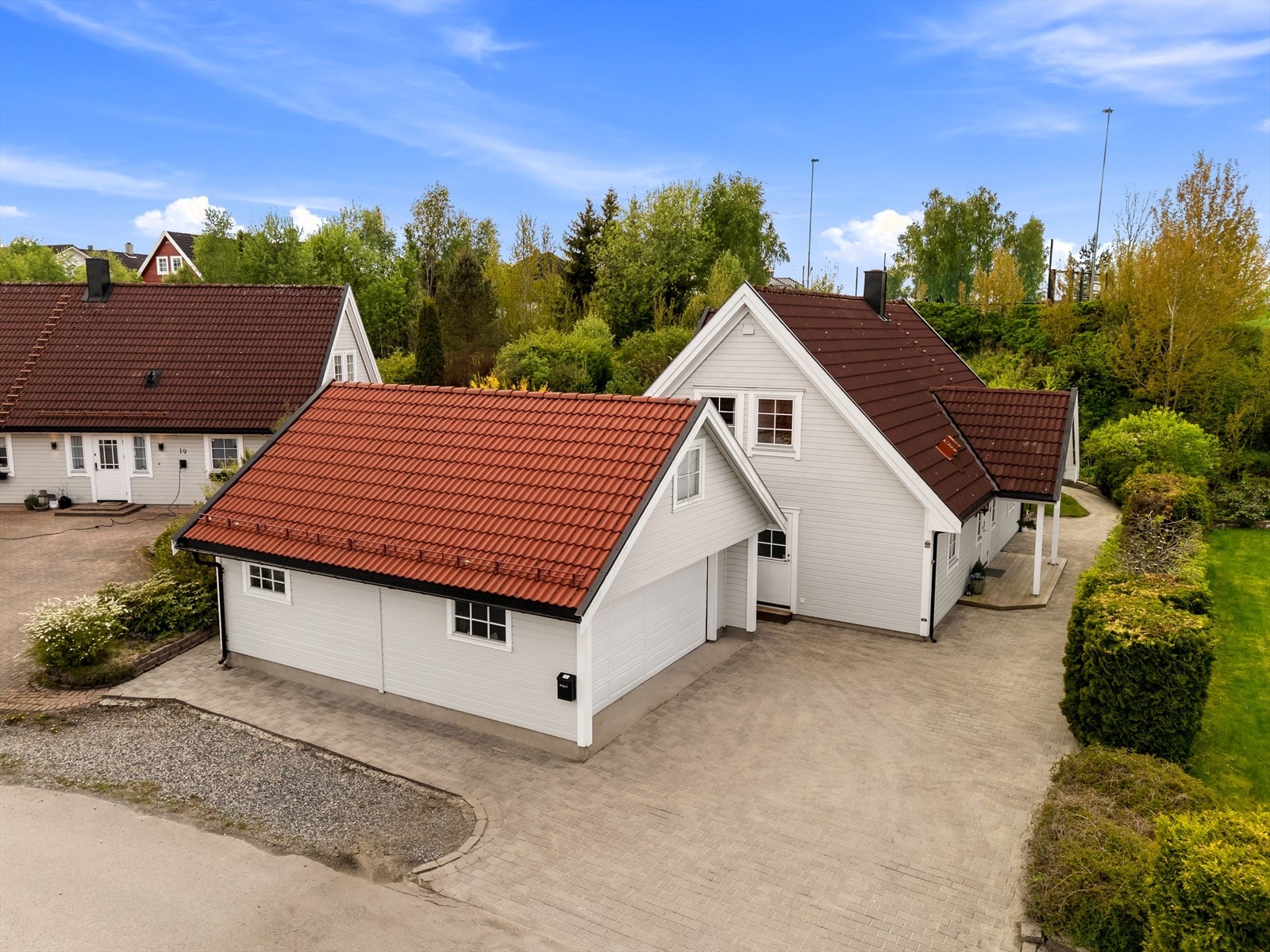 Enebolig med dobbelgarasje og en pent opparbeidet, belegningssteinbelagt gårdsplass. Galleribilde