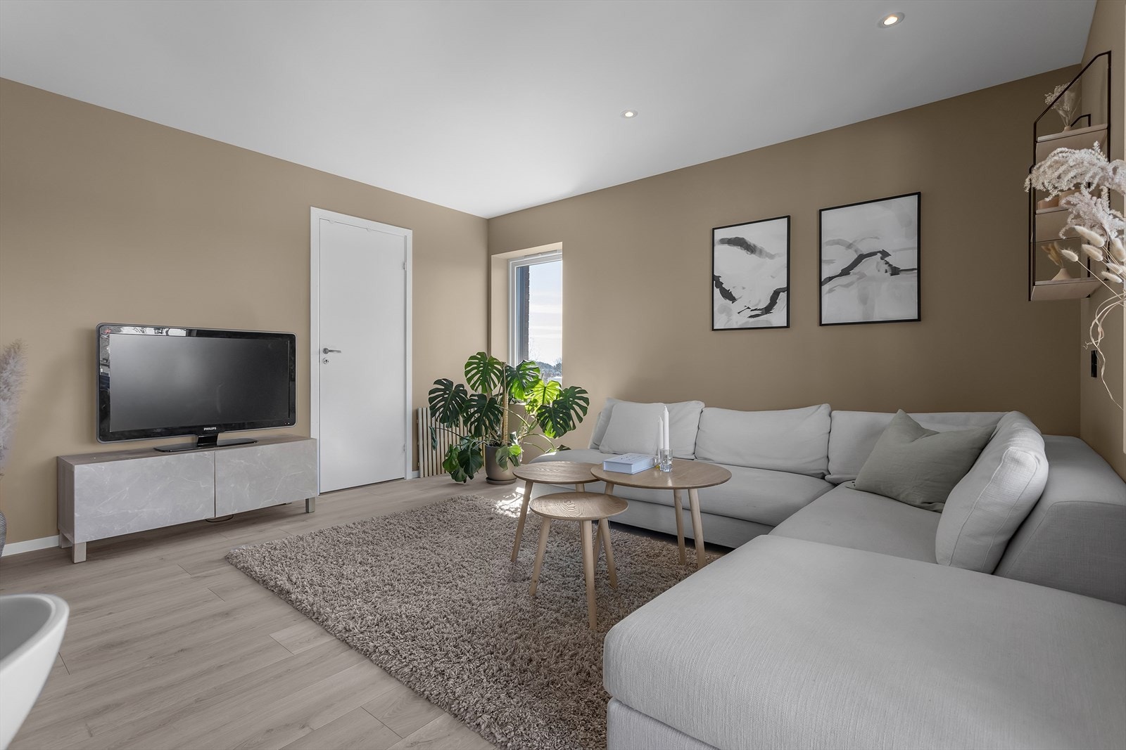 Ved renoveringen i 2022 ble stuen oppgradert med stilrene løsninger som listefrie overganger, spotter i taket, nye slette flater og et elegant enstavs laminatgulv som fullfører den gjennomførte og moderne stilen. Galleribilde
