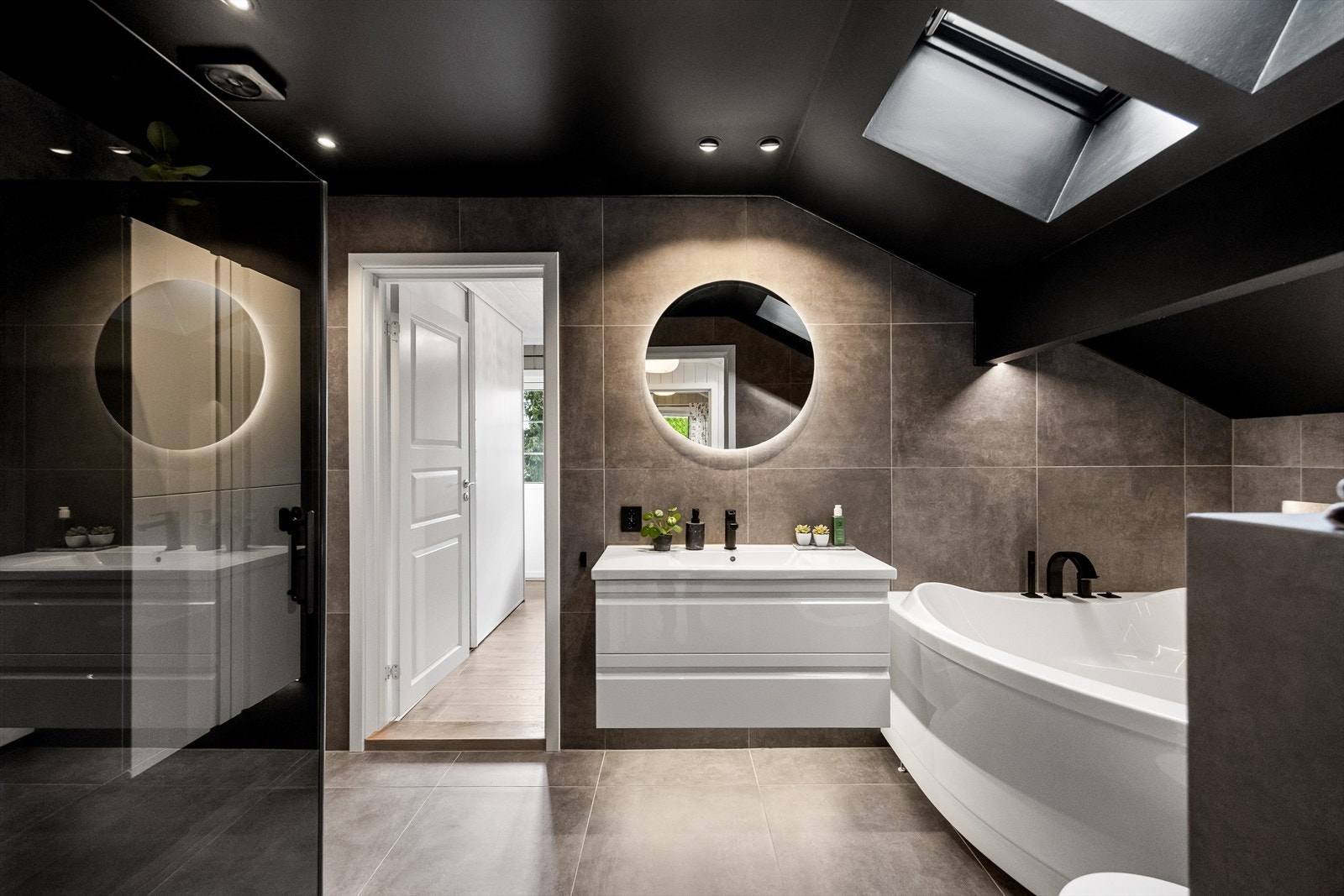 Badet i andre etasje ble pusset opp i 2018 og har en gjennomført stil med mørke tak og fliser. Galleribilde