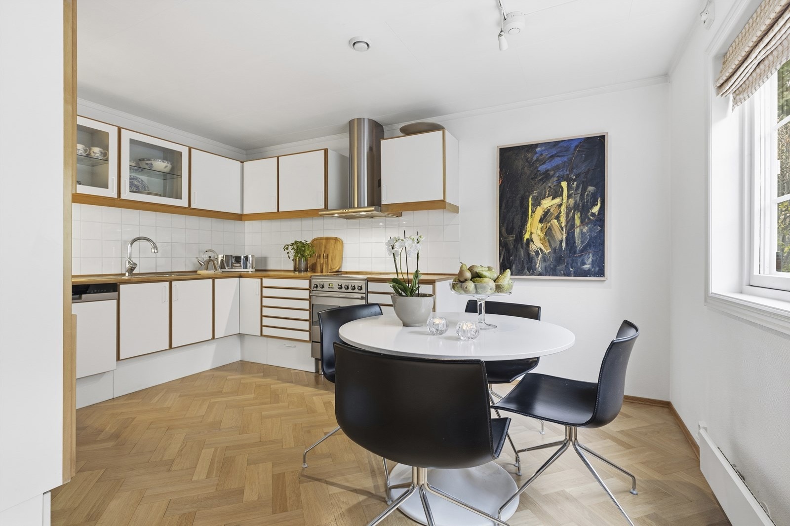 Hyggelig kjøkken med plass til frokostbord. Multiform kjøkken fra byggeåret, med glatte fronter og integrerte håndtak Galleribilde