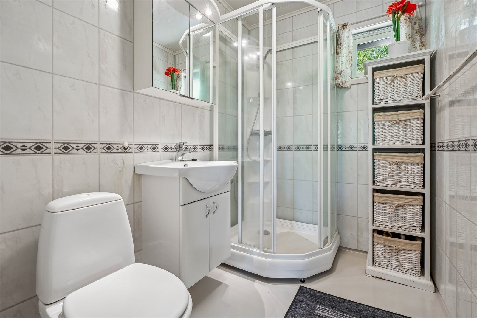 Badet i hovedetasjen er utstyrt med dusjkabinett, servant og toalett. Veggene fikk nye baderomsplater i 2006. Galleribilde
