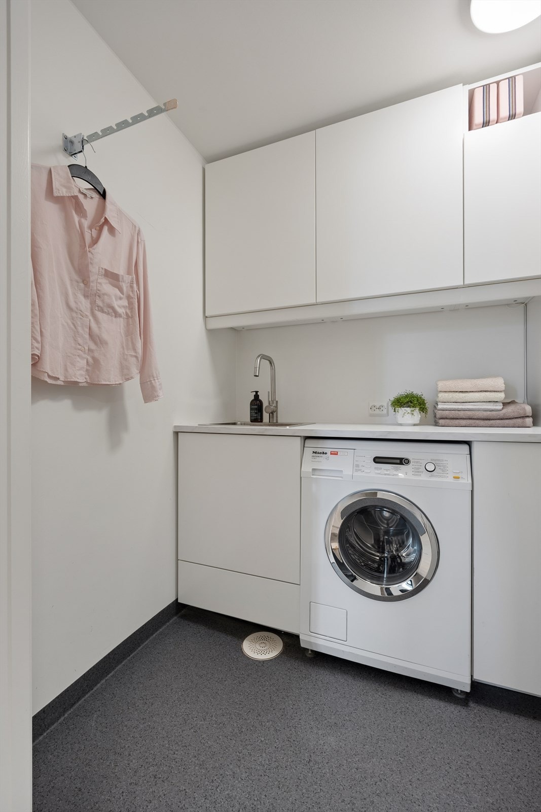 Rom innredet som vaskerom med opplegg for vaskemaskin, vinylbelegg på gulv og vannbåren gulvvarme. Veggene har malte plater. Det er balansert ventilasjon. Rommet var opprinnelig tegnet som bod, og bruksendringen er søknadspliktig. Galleribilde