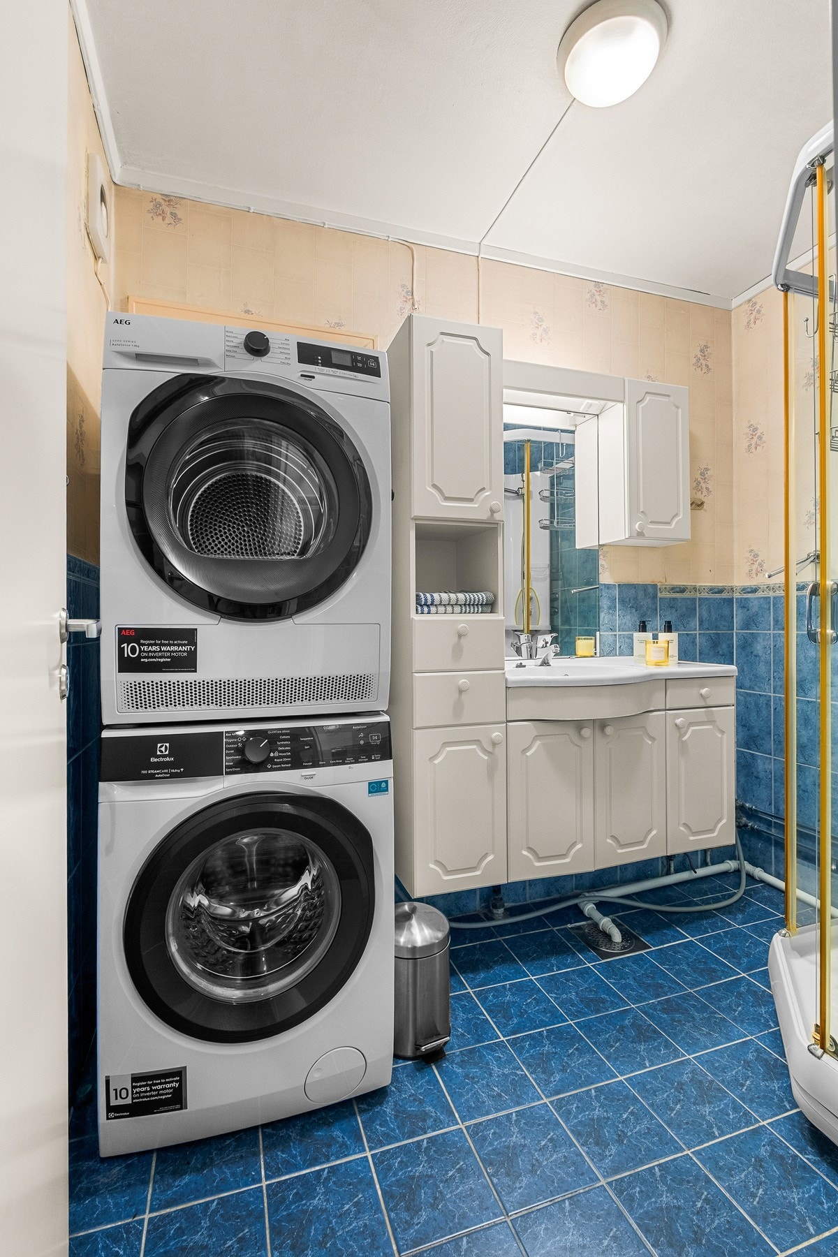 Badet er innredet med servantskap, speil m/overlys, veggskap og dusjkabinett. Galleribilde