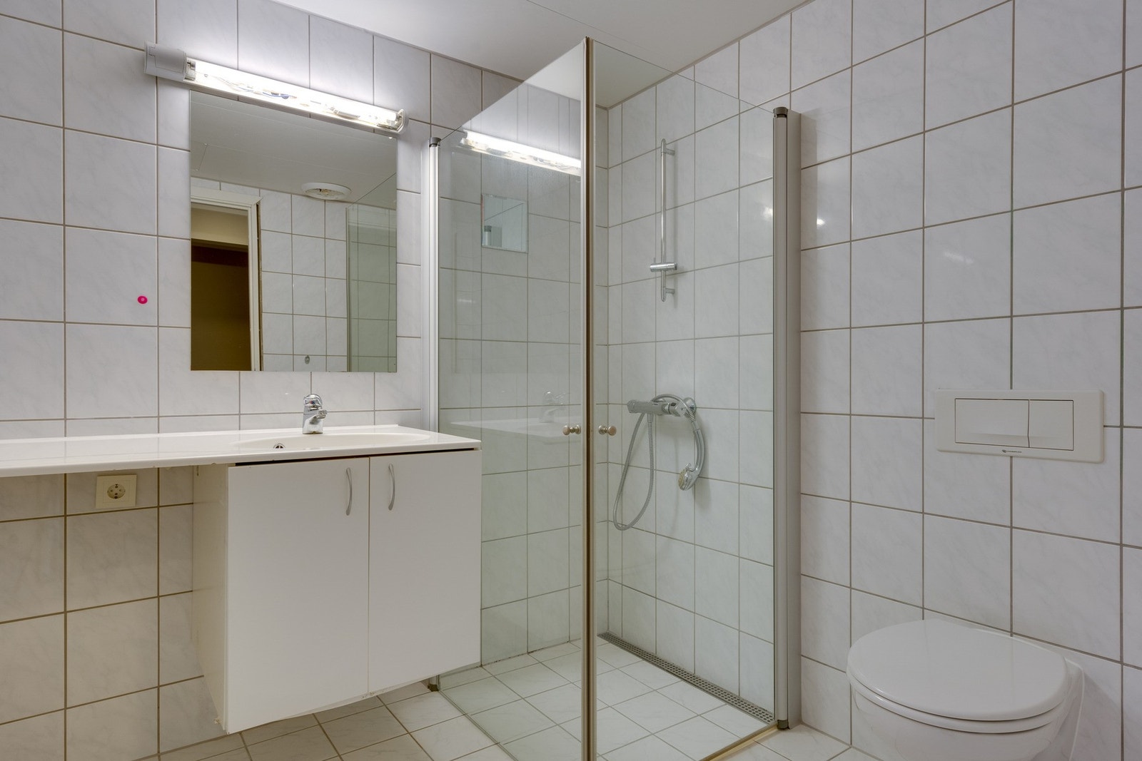Leiligheten har et lyst og pent flislagt bad med varmekabler i gulv, mekanisk ventilasjon og opplegg for vaskemaskin. Bildet er fra en annen leilighet med lik romløsning og størrelse. Badet til leiligheten som selges, har lik utførelse som dette badet. Galleribilde