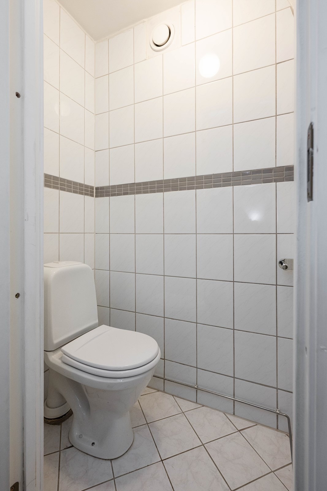 Praktisk, separat toalettrom med flislagte overflater og mekanisk avtrekk. Galleribilde