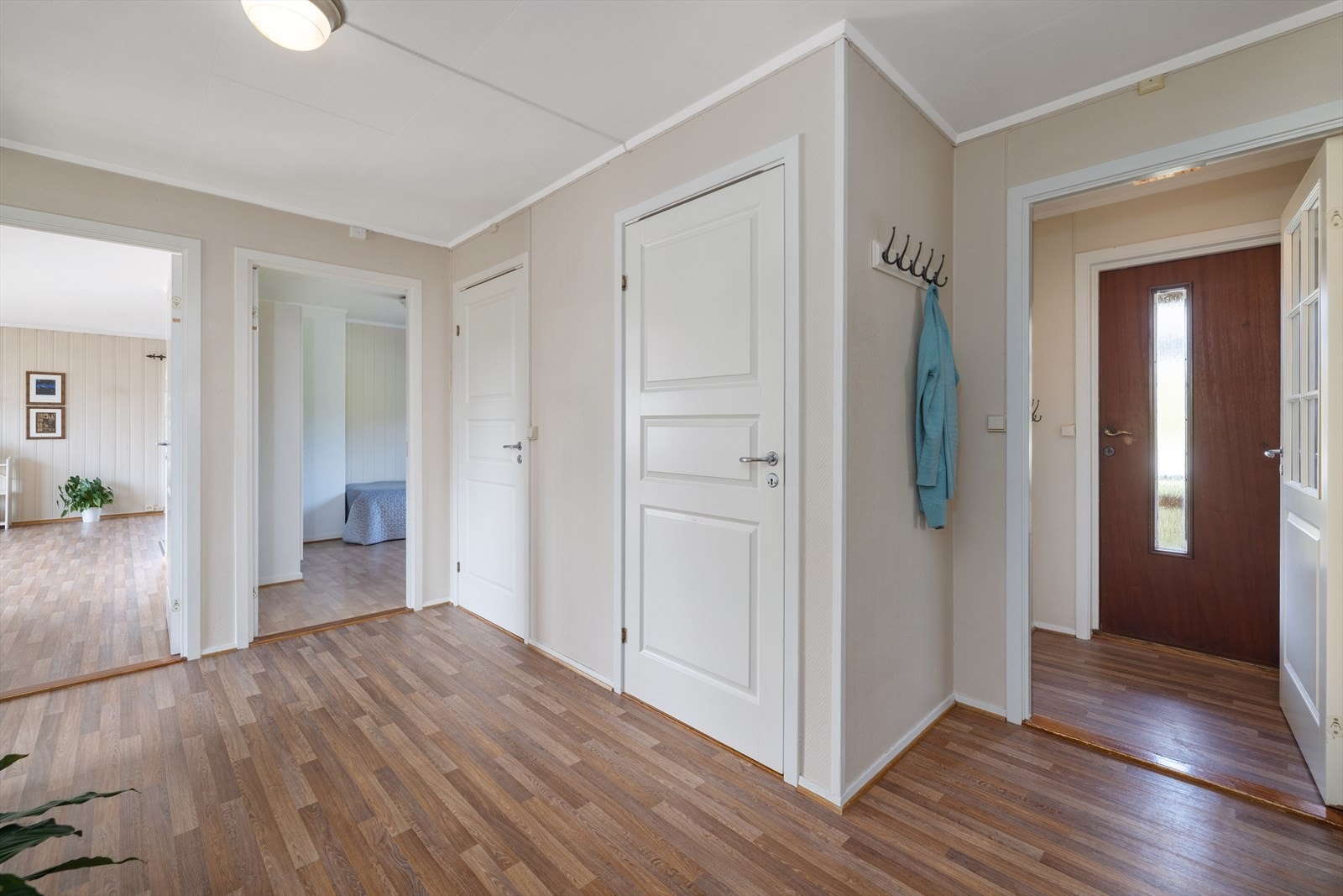 Fra entréen er det inngang til en romslig gang som fordeler adkomsten til boligens øvrige rom i første etasje. Galleribilde