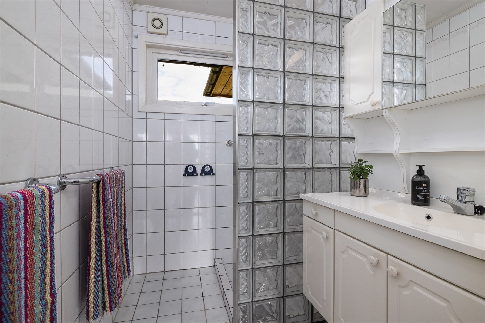 Badet i første etasje har flislagt gulv, flislagte vegger og en dusjnisje med glassvegg. Galleribilde