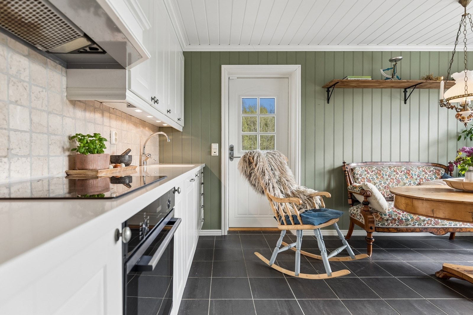 Kjøkkenet er innredet i en rustikk og landlig stil, og gulvet har praktiske fliser med varmekabler. Galleribilde